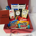 Assorted chocolate bars in a Christmas-themed gift box with a 'Merry Christmas' card.