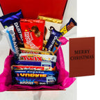 Assorted chocolate bars in a box with a 'Merry Christmas' card on a white background