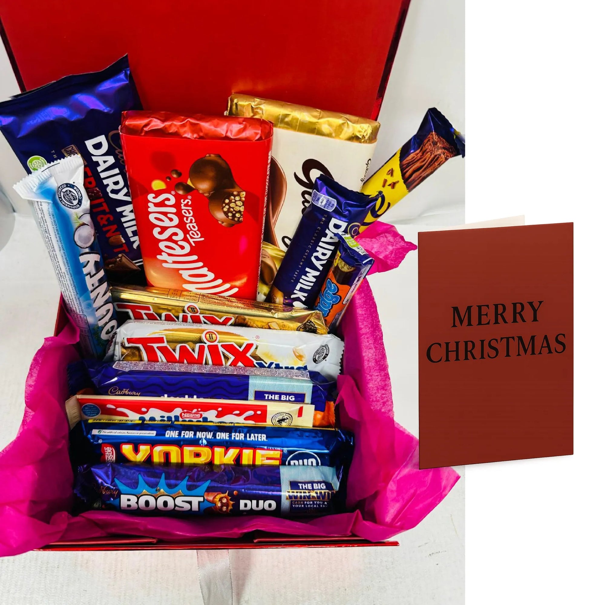 Assorted chocolate bars in a box with a 'Merry Christmas' card on a white background
