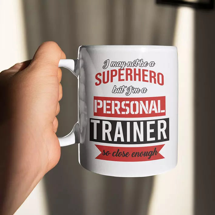 personalised ceramic mug featuring the quote “I May Not Be a Superhero But I'm a Personal Trainer So Close Enough”, a funny gift for fitness coaches.