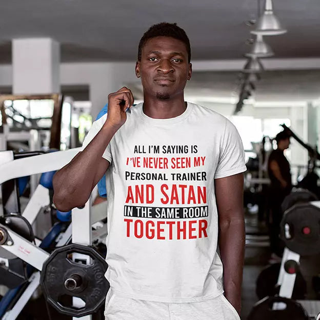 Personalised gym T-shirt featuring the funny quote about never seeing a personal trainer and Satan in the same room, with a custom name beneath the print.