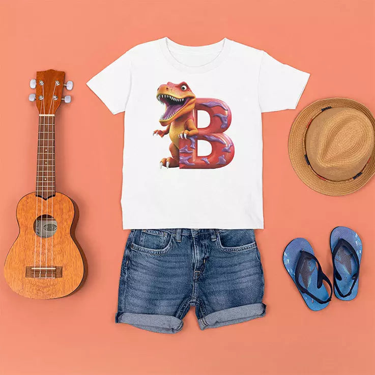 White t-shirt with dinosaur design, denim shorts, ukulele, straw hat, and blue flip-flops on a peach background