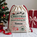 Personalised Christmas Express Delivery canvas sack with custom name, Santa's sleigh, reindeer silhouettes and festive North Pole postal artwork.