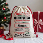 Personalised Santa Express Christmas sack with custom name, vintage North Pole delivery artwork, festive red and green print and cotton drawstring closure.