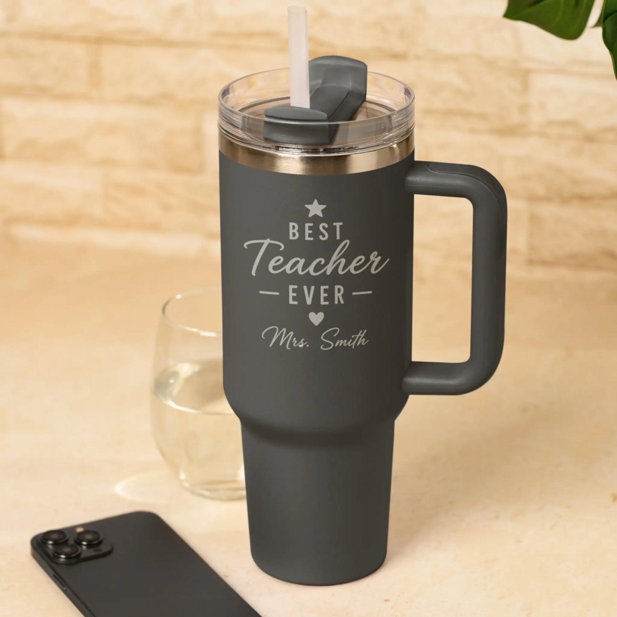 Close-up of a Personalised Best Teacher Ever Black Tumbler engraved with teacher name, insulated travel mug with straw and handle.