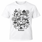 White personalised Diwali T-shirt featuring black Eat Sweets Light Diyas Repeat lettering, festive diyas, Indian sweets and custom name.