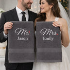 Newlywed couple holding personalised Mr and Mrs towels with embroidered names – luxury wedding gift