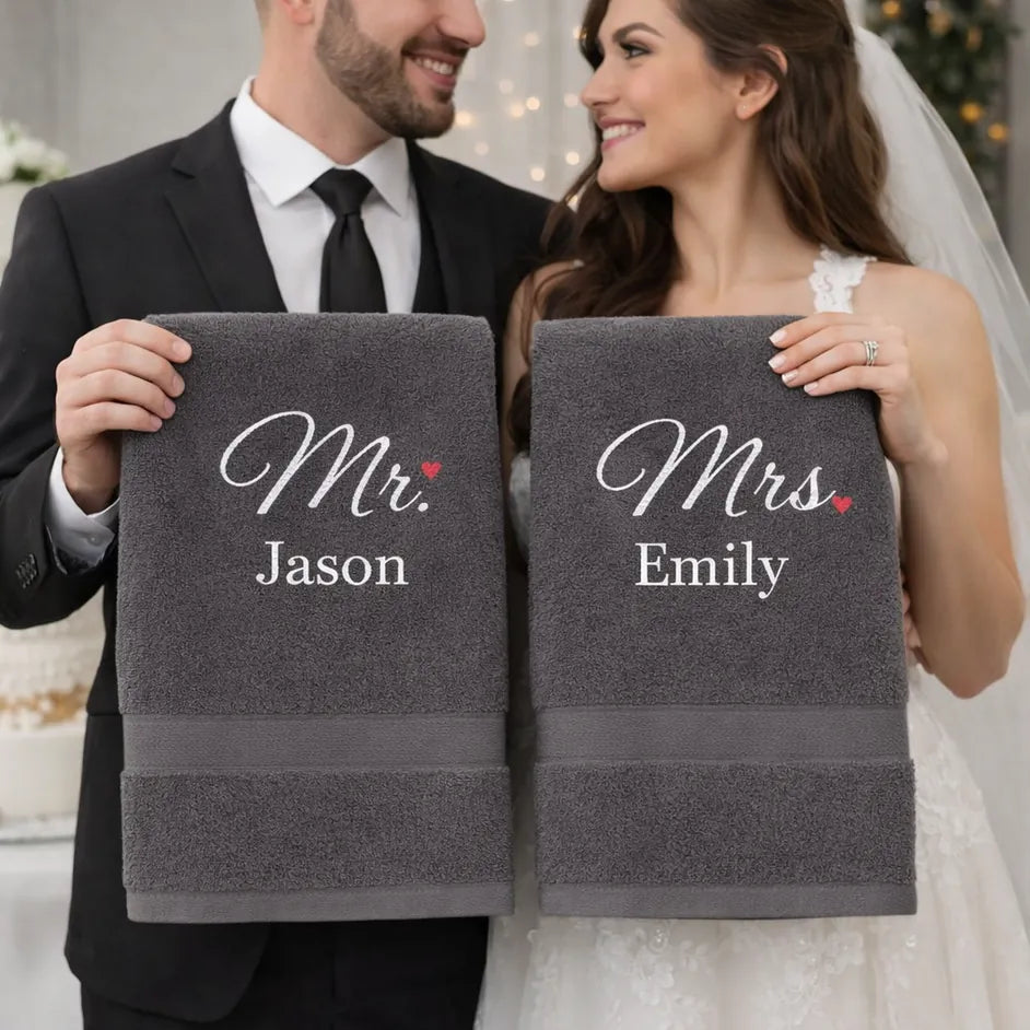 Newlywed couple holding personalised Mr and Mrs towels with embroidered names – luxury wedding gift