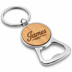 A personalized bottle opener keychain featuring a round natural wood inlay engraved with the name 'James' in script, attached to a polished silver metal key ring and opener blade, shown on a clean white background.