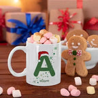 Personalised Christmas ceramic mug featuring a custom name and matching initial, with festive artwork printed on both sides.