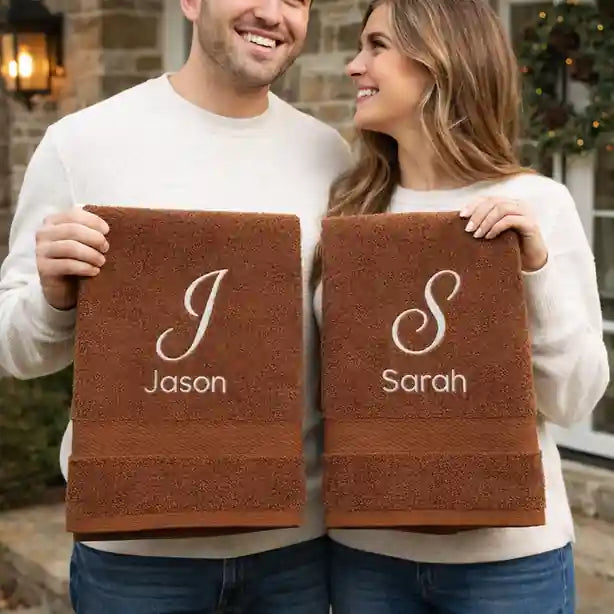 Couple holding personalised embroidered towels with names – luxury gift for couples