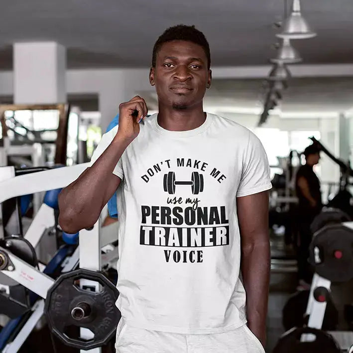 Personalised cotton T-shirt displaying “Don't Make Me Use My Personal Trainer Voice” quote with a custom name printed beneath the design.