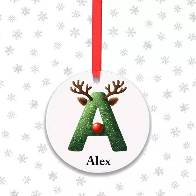 Personalised round reindeer Christmas bauble featuring a custom name and festive initial design on a glossy aluminium decoration.
