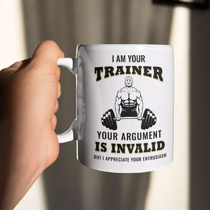 White ceramic personal trainer mug displaying the “I'm Your Trainer Your Argument Is Invalid But I Appreciate Your Enthusiasm” quote on the front.