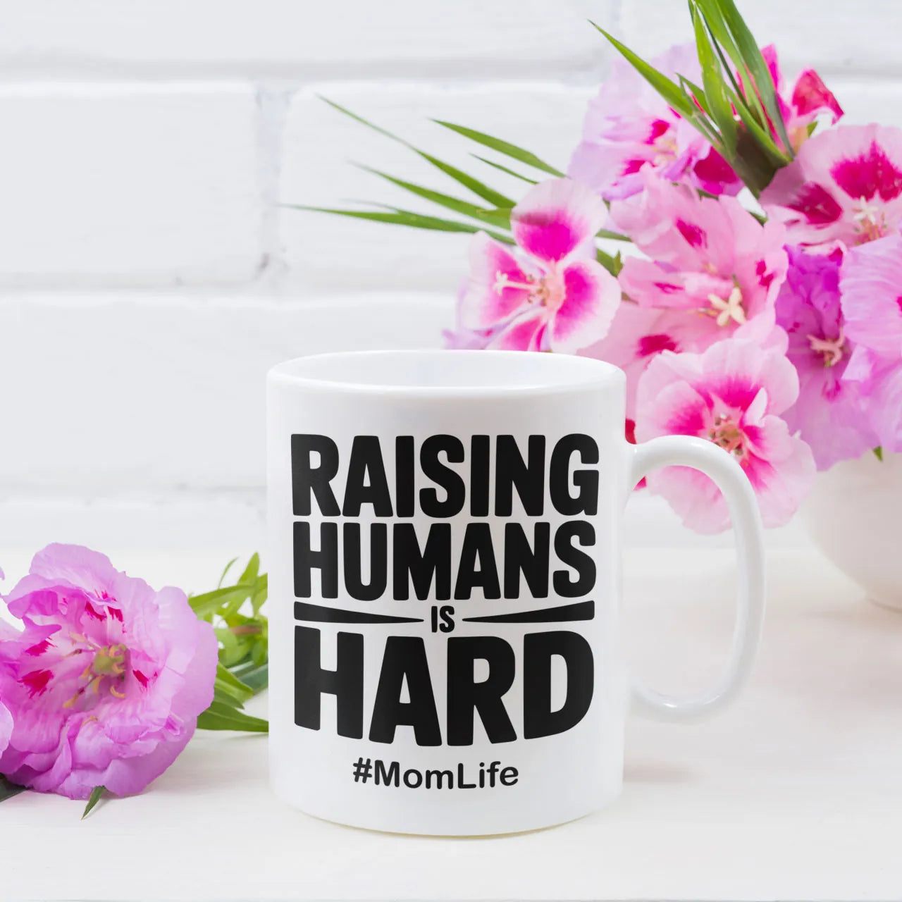 Funny ceramic coffee mug with "Raising Humans Is Hard" quote, an honest and relatable Mother's Day gift for mums, high-quality print UK.