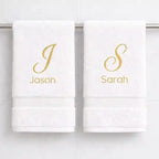 White luxury cotton towels with personalised gold embroidered names hanging in bathroom