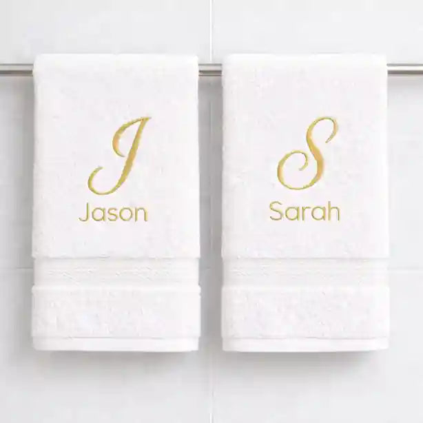 White luxury cotton towels with personalised gold embroidered names hanging in bathroom