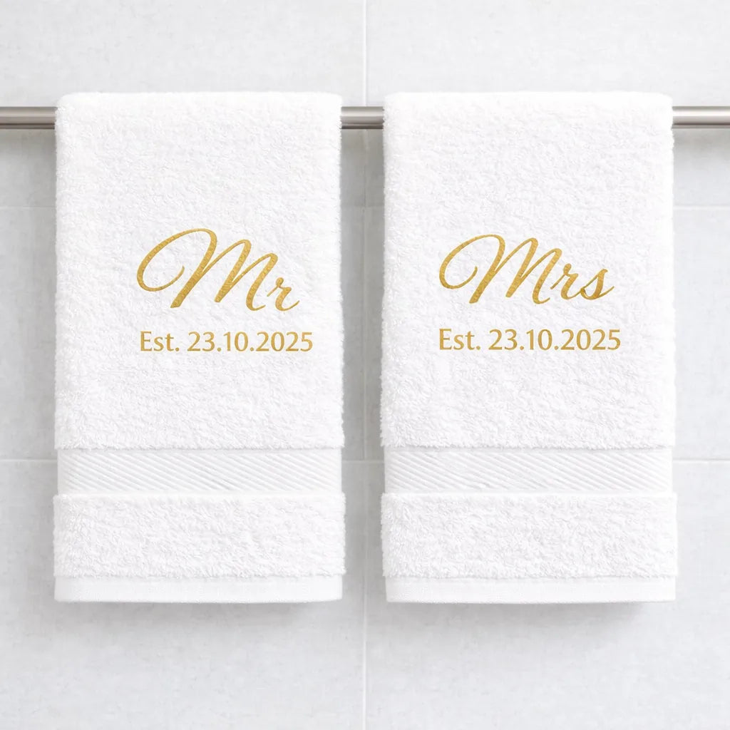 White luxury cotton Mr and Mrs towels with gold embroidered anniversary date hanging in bathroom
